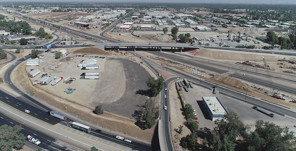 From above, a view of two freeways intersecting with roads and on-ramps woven above and below them.