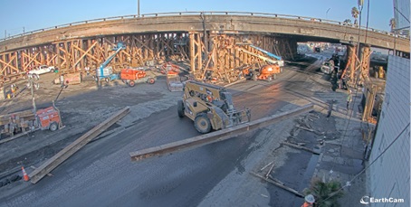Photo of Interstate 10 repair status following a fire on Nov 11, 2023. Workers use heavy equipment to move lumber that will shore up the damaged infrastructure. 