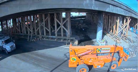 Photo of Interstate 10 repair status following a fire on Nov 11, 2023. Workers use heavy equipment to move lumber that will shore up the damaged infrastructure. 