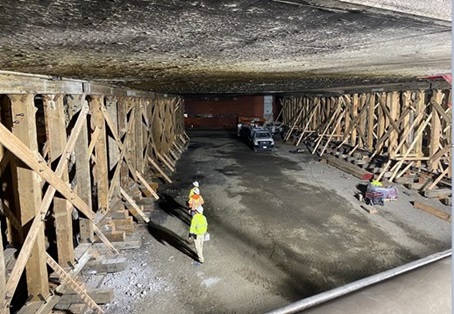 A photo taken on Nov 19, 2023, capturing the repairs in the final hours to Fix the I-10 before lanes reopened weeks early. Workers do a walkthrough to inspect the shoring below the freeway infrastructure. 