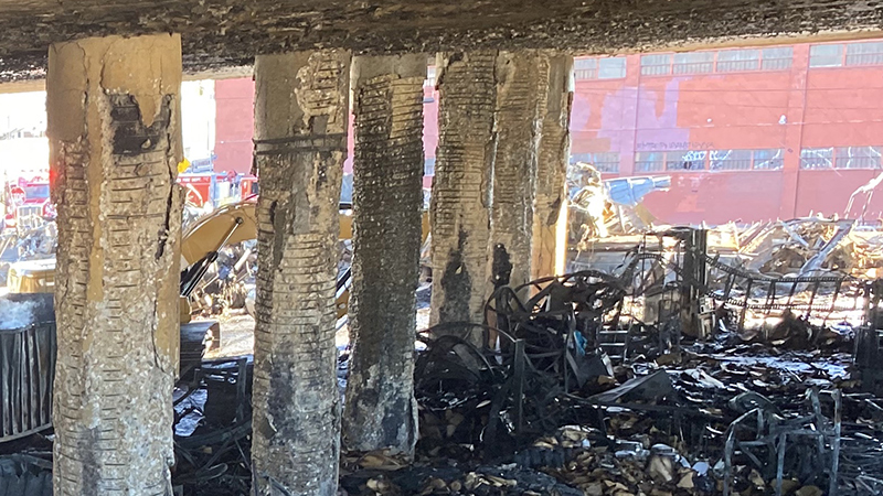 A close up photo of the damaged support pillars surrounded by burned vehicles underneath a section of the Interstate 10 Closure at Alameda Street in Downtown Los Angeles due to a catastrophic fire on November 11, 2023.