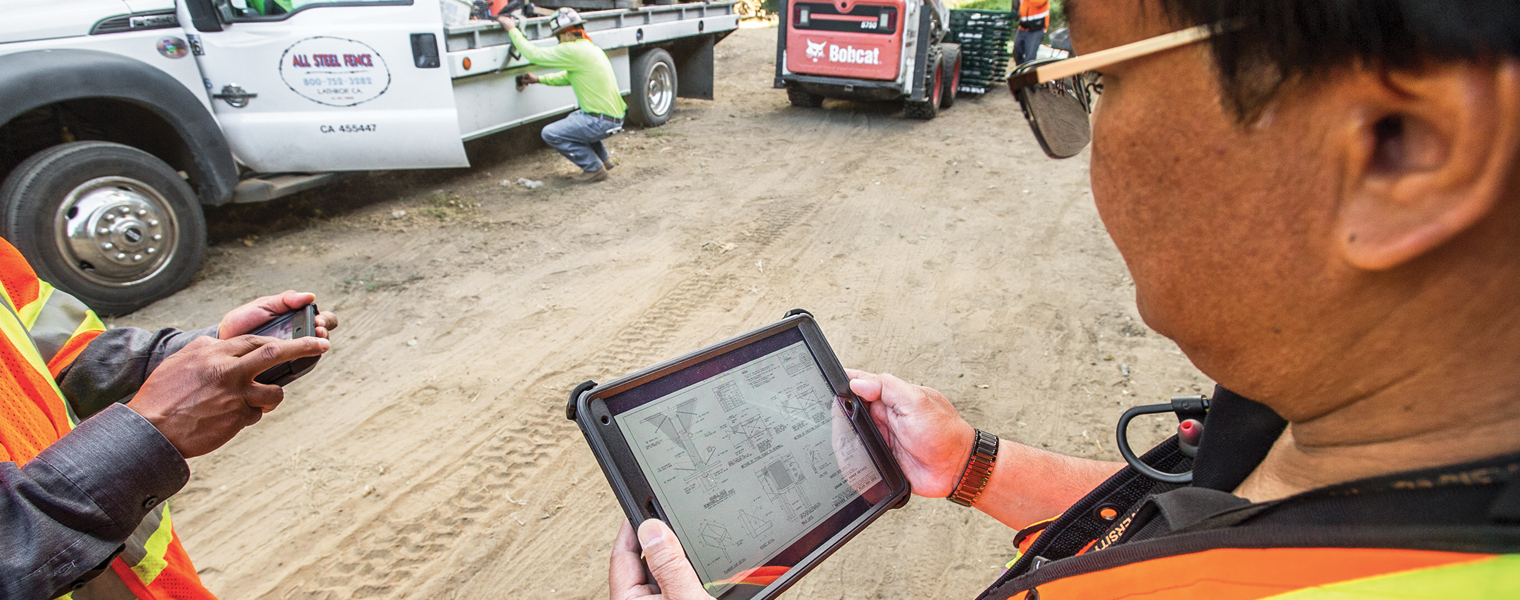 Photo of a Caltrans worker holding a tablet at a job site