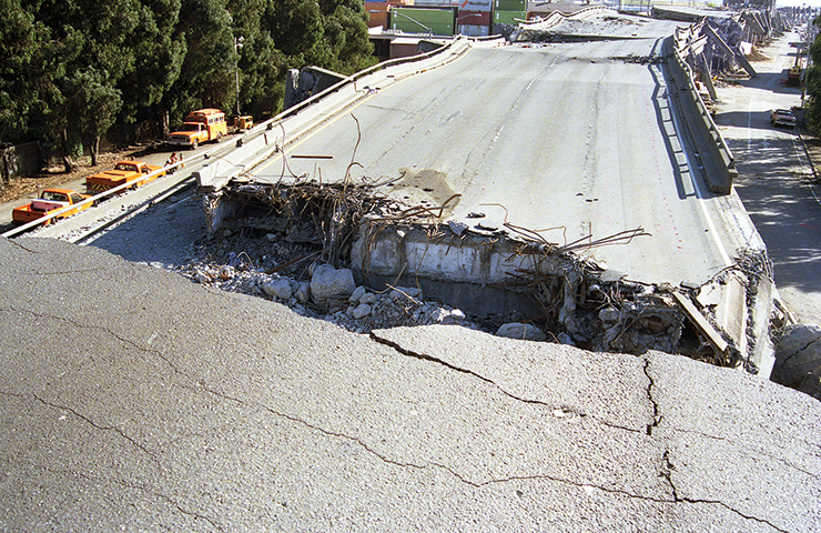 Photo depicts a collapsed portion of the 880 expressway.