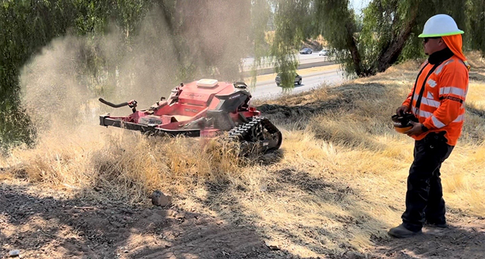 Caltrans worker using a robot mower