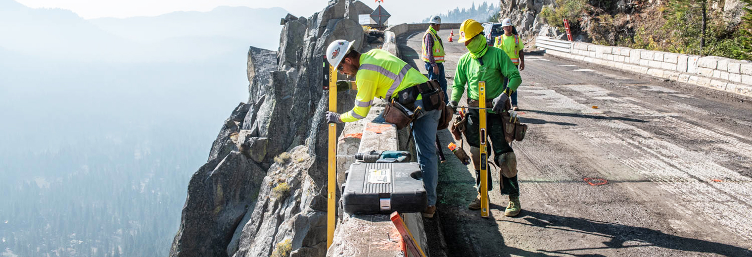 Photo of construction workers taking measurements of the bridge railing