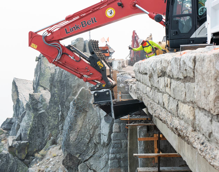 Photo of bulldozer tearing down the old bridge guardrail.