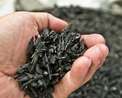 Photo: close-up view of a hand holding small bits of shredded rubber to be used for transportation projects