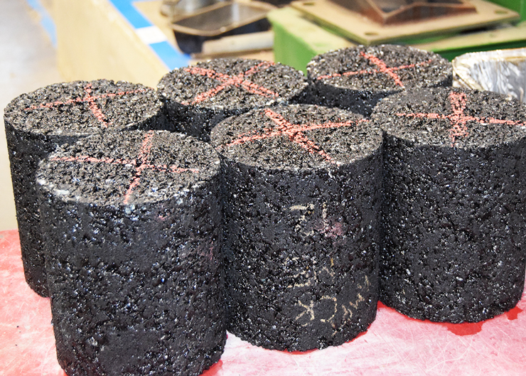 Photo of six cylindrical core pavement samples on a table.