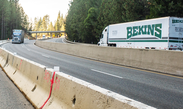 Photo of two trucks traveling on the state highway