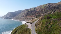 California Highway 1 at Rat Creek near Big Sur: aerial view along the coastline of the Pacific Ocean, looking north. The Rat Creek project site is in the center of the frame and the picturesque Lime Creek Bridge is to its left.