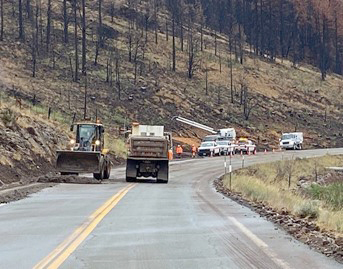 Caltrans highway workers on State Route 89 near Markleeville, California (about 30 miles south of Lake Tahoe) use heavy equipment during an emergency project to clear mudslide debris so that the road can be reopened.