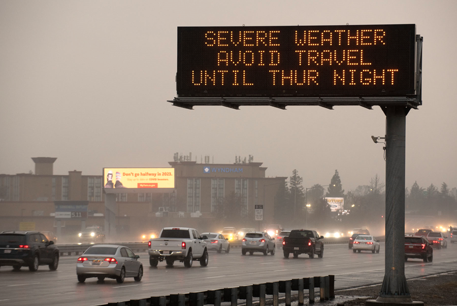 Photo of an electronic message sign displaying, "Severe weather avoid travel Thur night," next to a busy freeway.