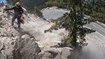 A Caltrans worker on a "scaling crew" rappels down a mountain face and knocks boulders down to the closed road below as part of a proactive Maintenance program that protects motorists traveling on rockfall-prone state highways.