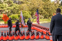 Caltrans Director Toks Omishakin watches the Caltrans Honor Guard present the U.S. and California flags; an orange sign in the background reminds motorists to "Slow for the Cone Zone" - 31st Annual Caltrans Workers Memorial Ceremony April 29, 2021 - California State Capitol, Sacramento