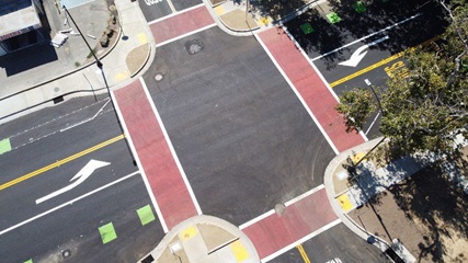 Image of an intersection that has bulbouts curb extensions that shorten the crossing distance and provide more area and visibility for pedestrians